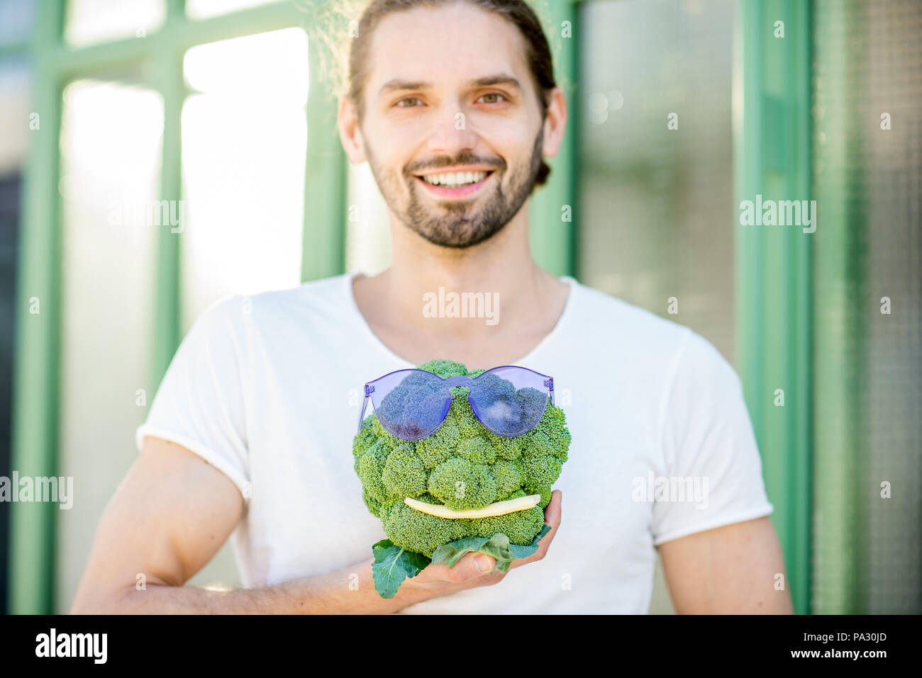 Funny portrait of a man with his vegetable friend made of broccoli