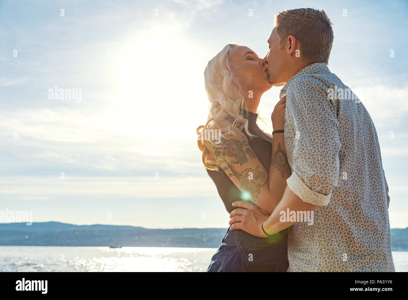 Romantic couple kissing and embrace on beach a sunny day Stock Photo