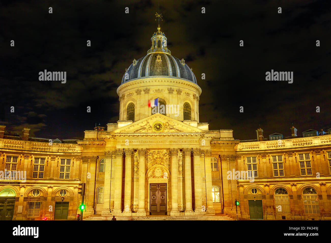 Central dome of Institut de France building, a French learned society group of five academies in Paris, France, Europe. Institut de France with Bibliotheque Nazarine illuminated by night. Stock Photo