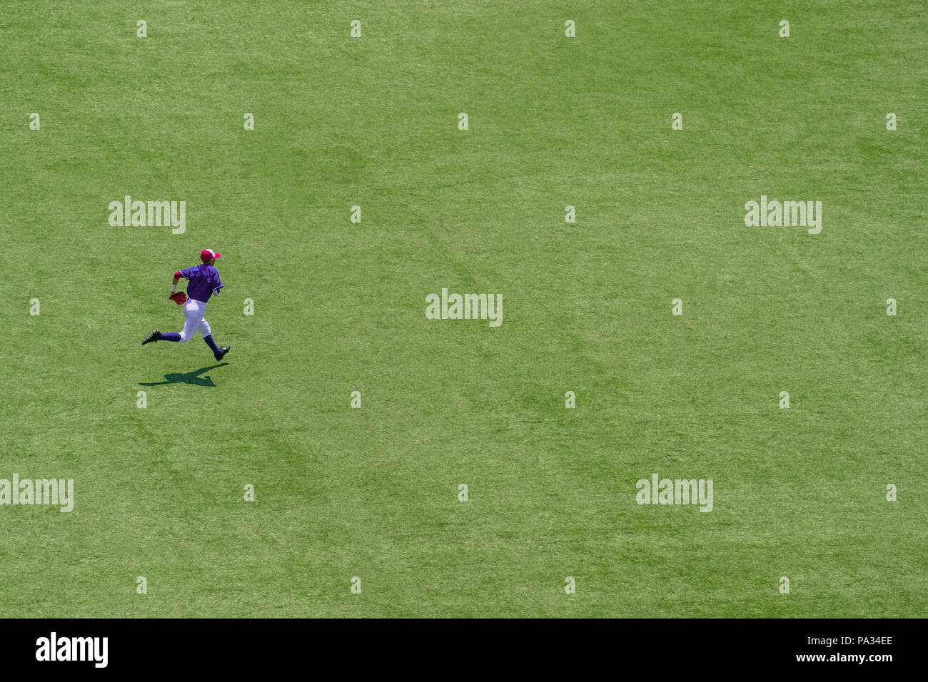 American youth baseball player running on field Stock Photo