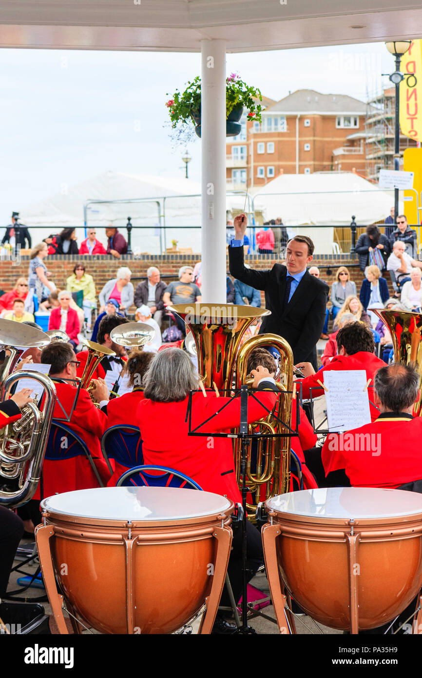 Salvation Army band performing on summer's day at the bandstand on Broadstairs seafront. Over the shoulder view from back of orchestra. Stock Photo