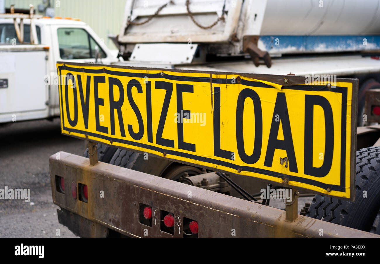 Black on yellow oversize load sign Installed on the back of big rig