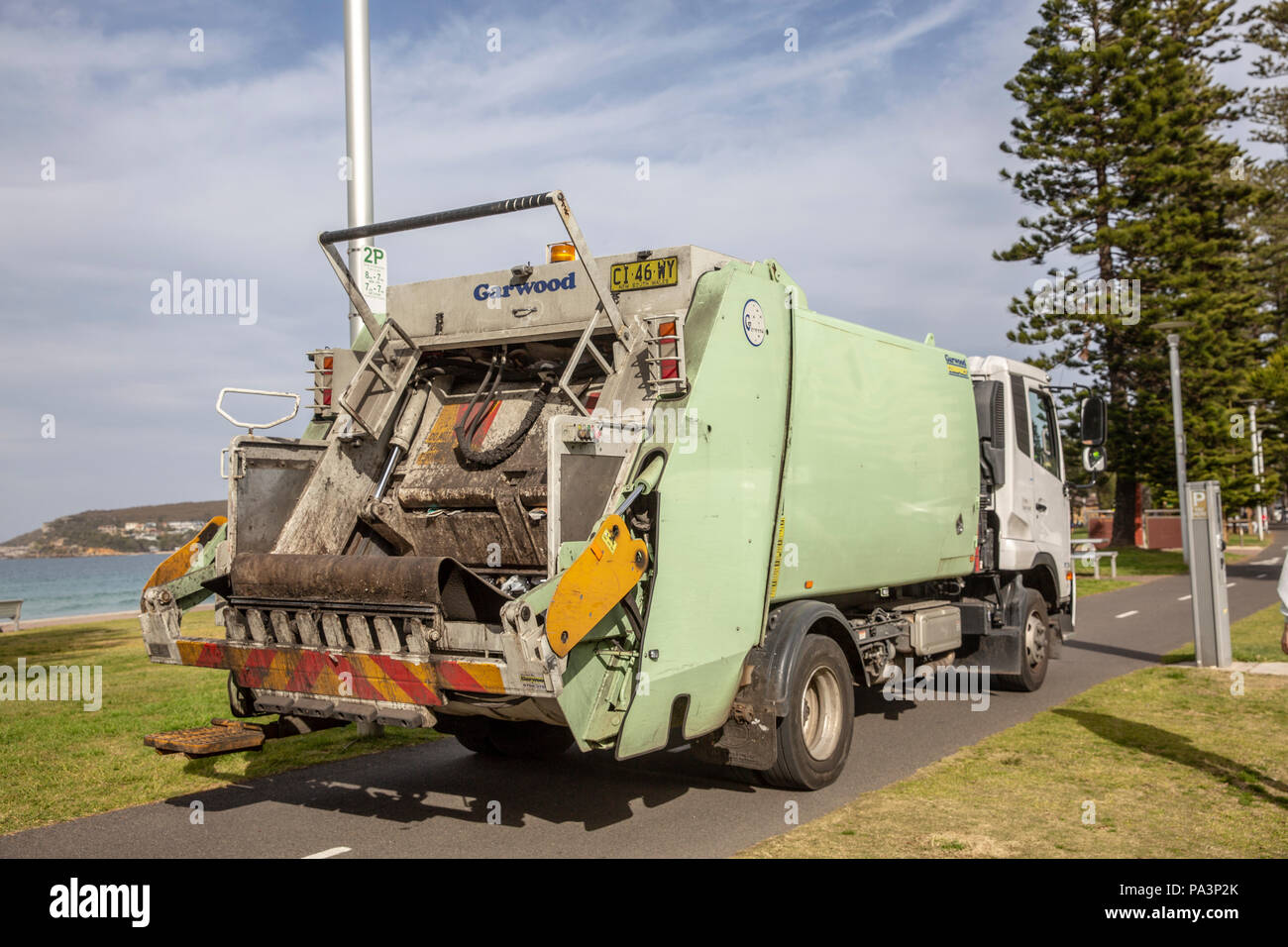 Council truck compactor collecting rubbish and garbage from bins in