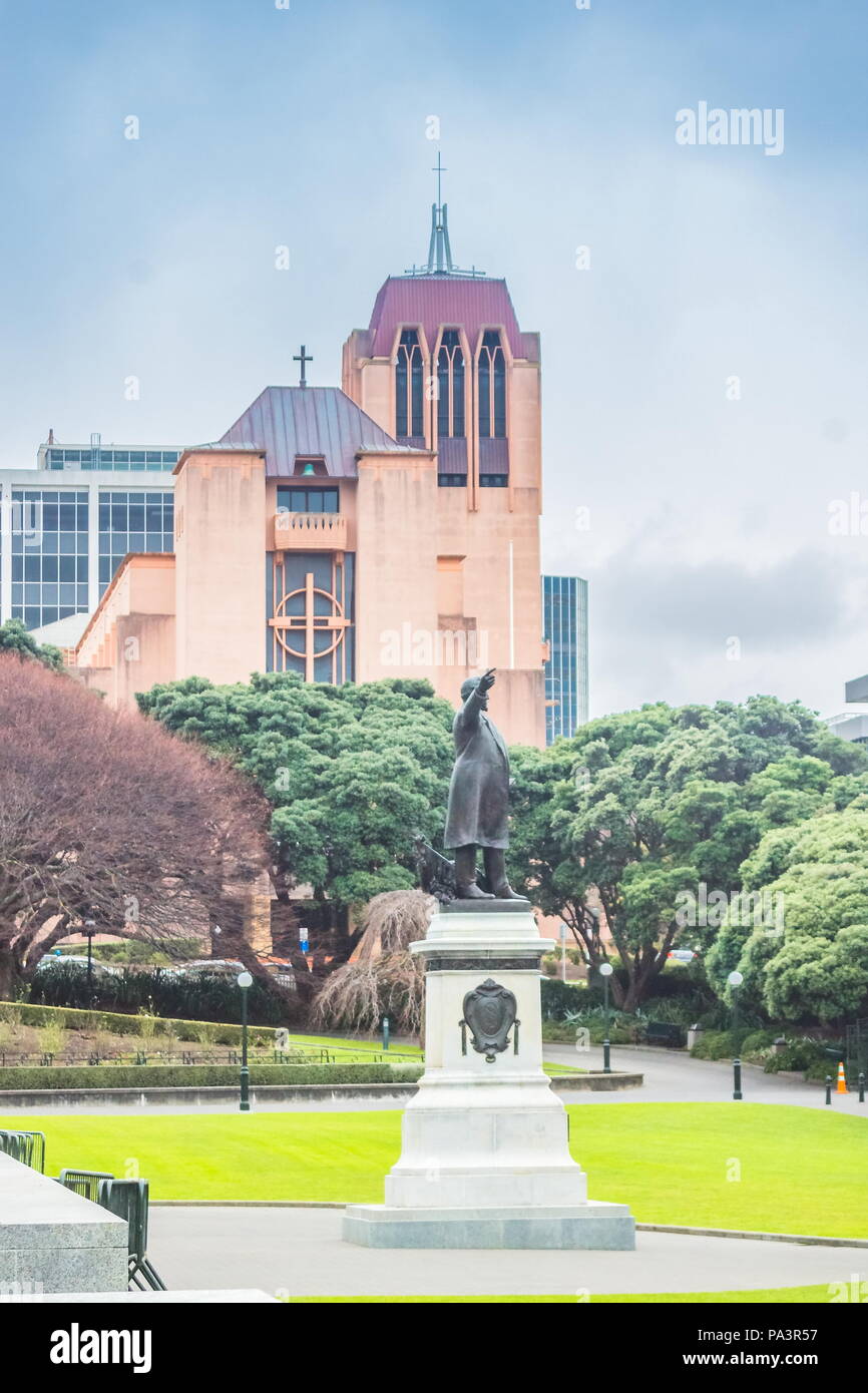 Wellington, New Zealand - July 18, 2016: A monumental statue of Richard John Seddon inside Parliament Grounds with the landmark Cathedral of St Paul i Stock Photo