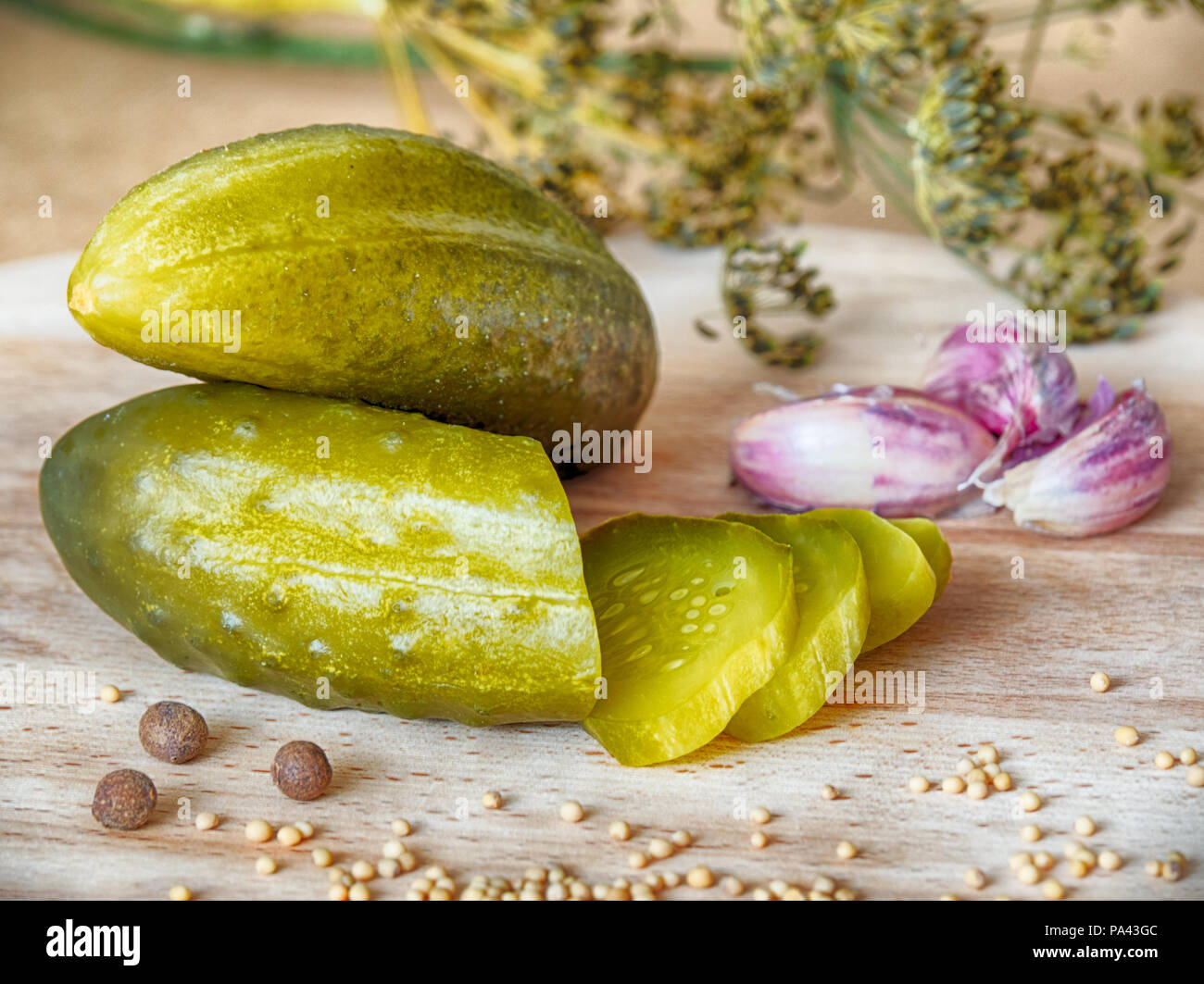 Pickled cucumber, garlic, dill and mustard on a wooden board Stock