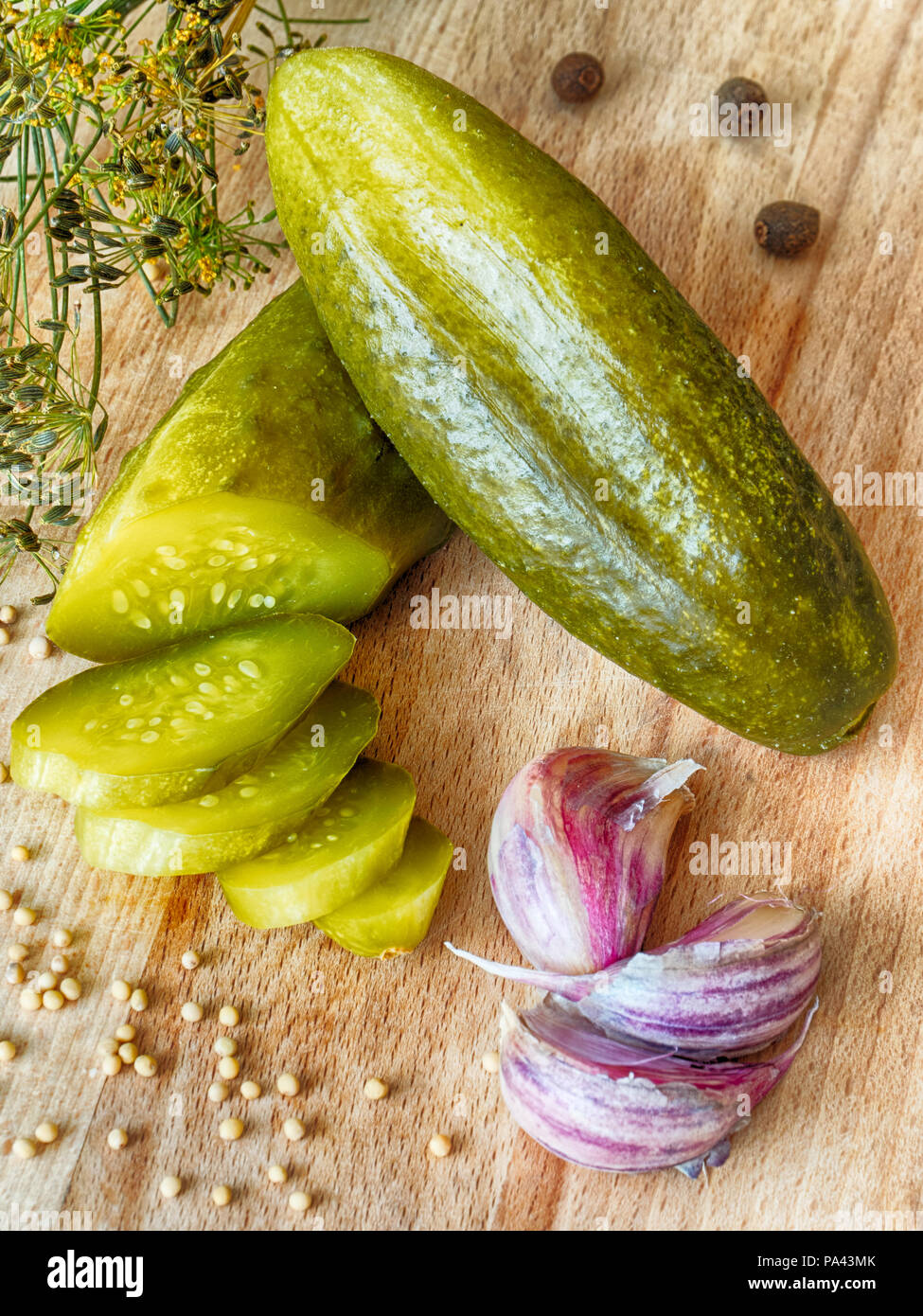 Pickled cucumber, garlic, dill and mustard on a wooden board Stock