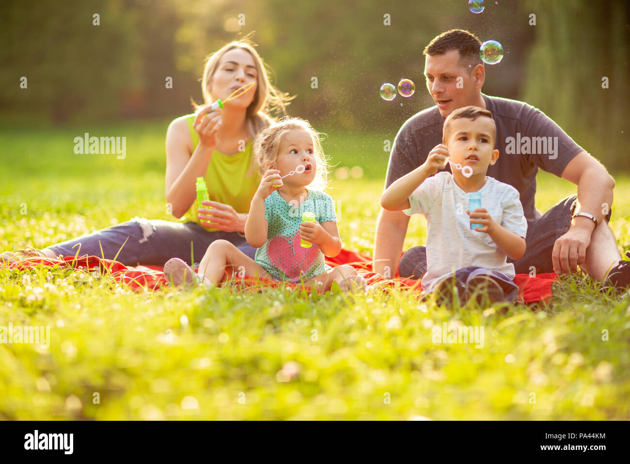 Young family with children blow soap bubbles outdoor Stock Photo - Alamy
