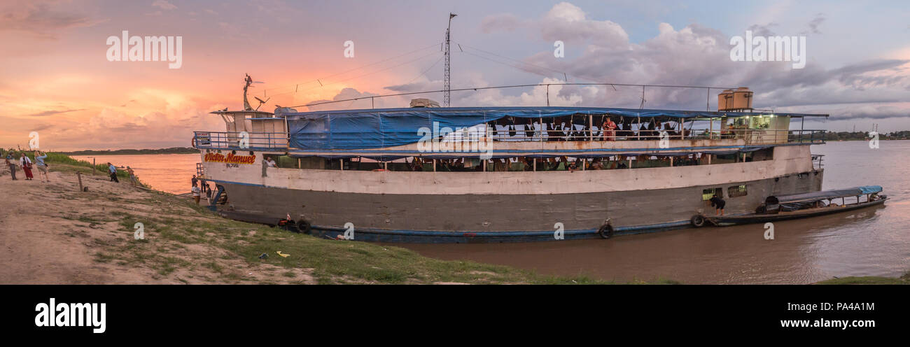 Santa Rosa, Peru - December 11, 2017: Cargo boat on the Amazon river on the background of the sun set Stock Photo