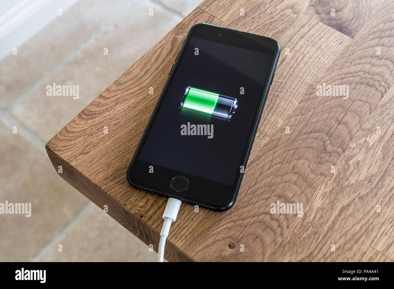 Mobile phone on charge plugged on Stock Photo