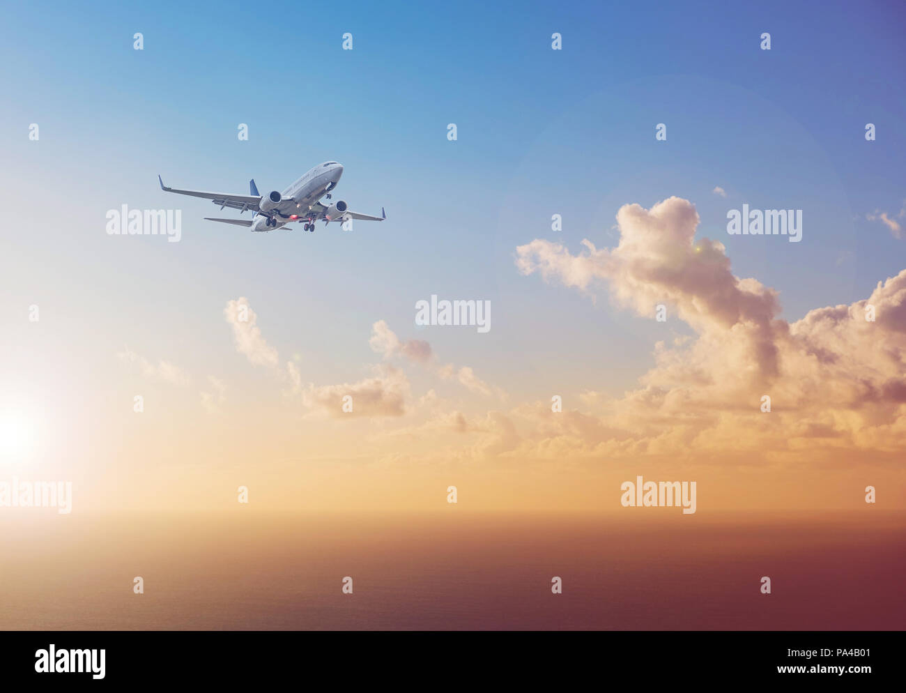 airplane flying above  ocean with sunset sky background   - travel concept Stock Photo