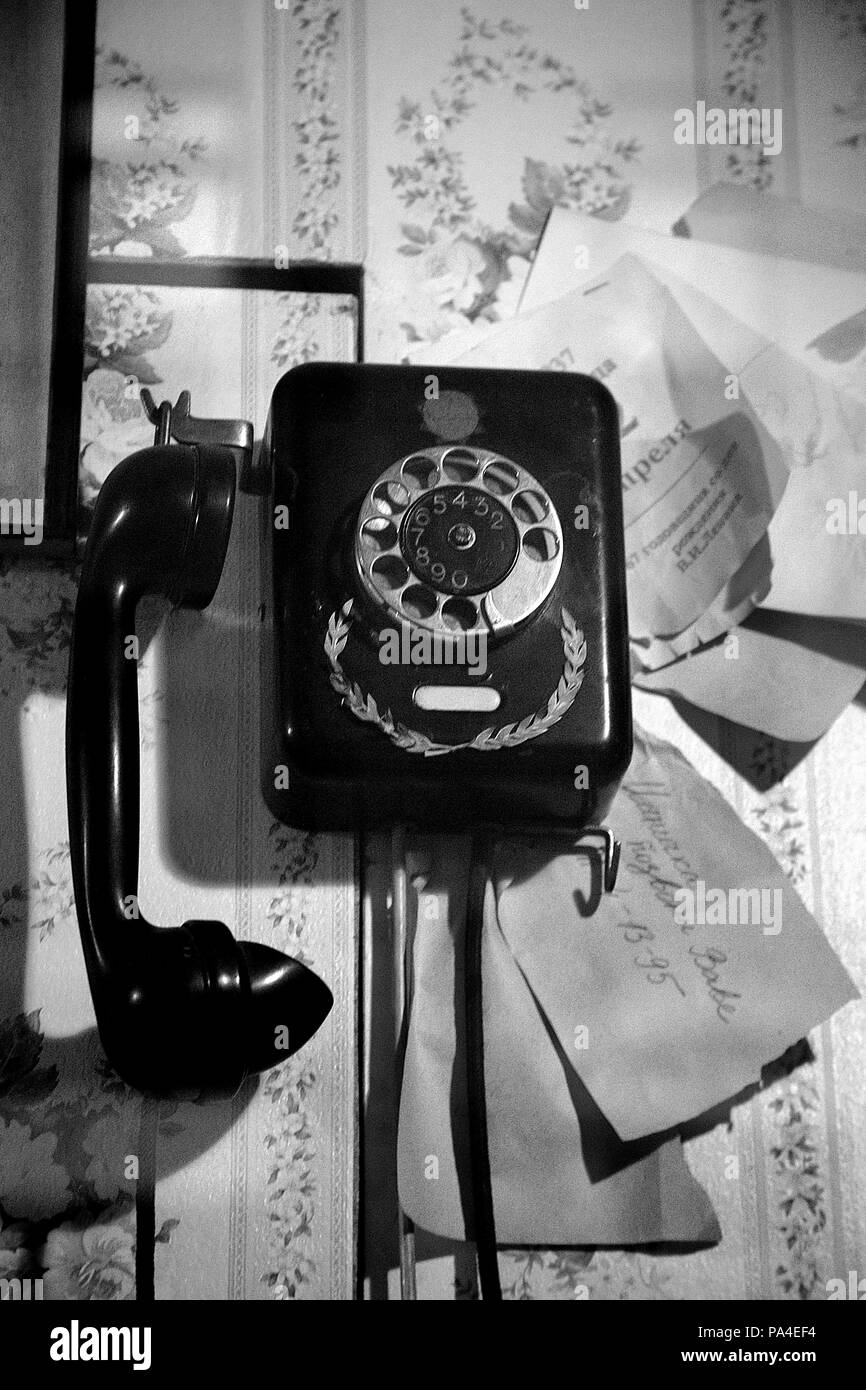 Vintage wall-mounted rotary telephone and a bunch of notes Stock Photo