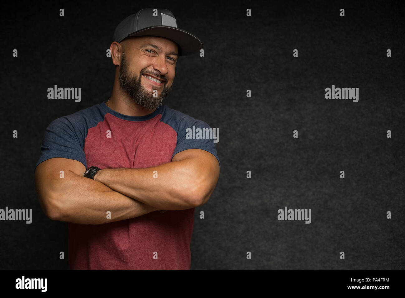 Portrait of Black bearded male in cap over grey background. Stock Photo
