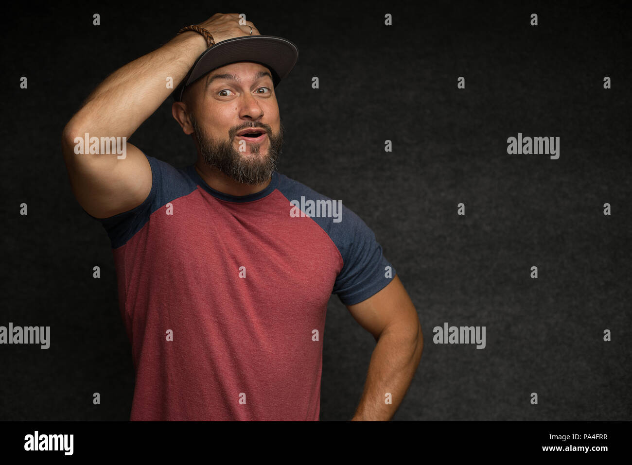 Portrait of Black bearded male in cap over grey background. Stock Photo