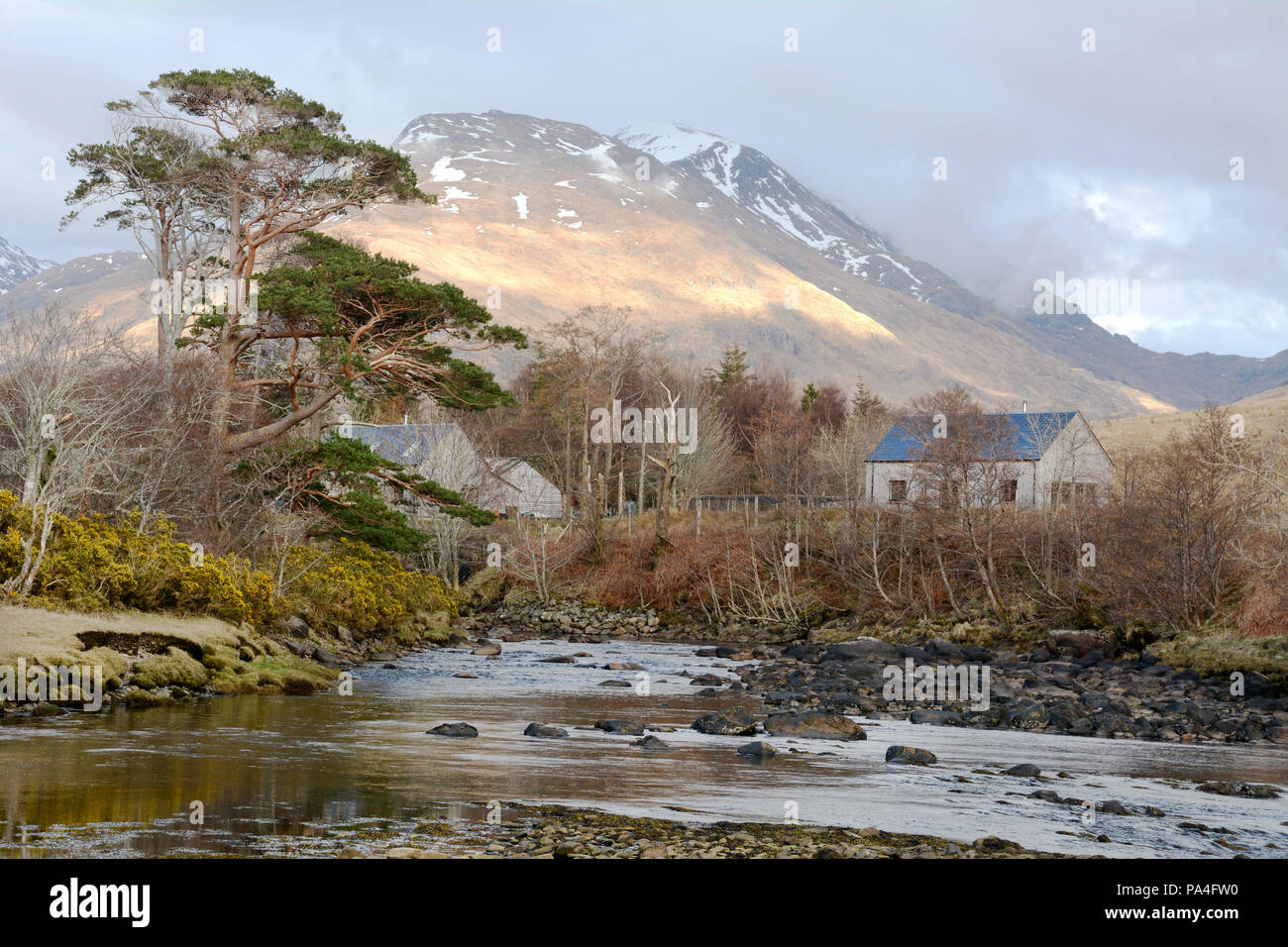 Homes beside a river under the mountains on Loch Nevis, in Inverie on