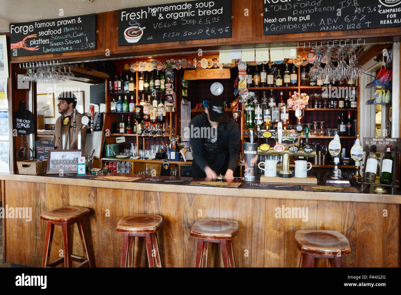 The bar and bartenders at The Old Forge, the most remote pub in the mainland UK, in the town of Inverie, Knoydart Peninsula, Scotland, Great Britain. Stock Photo