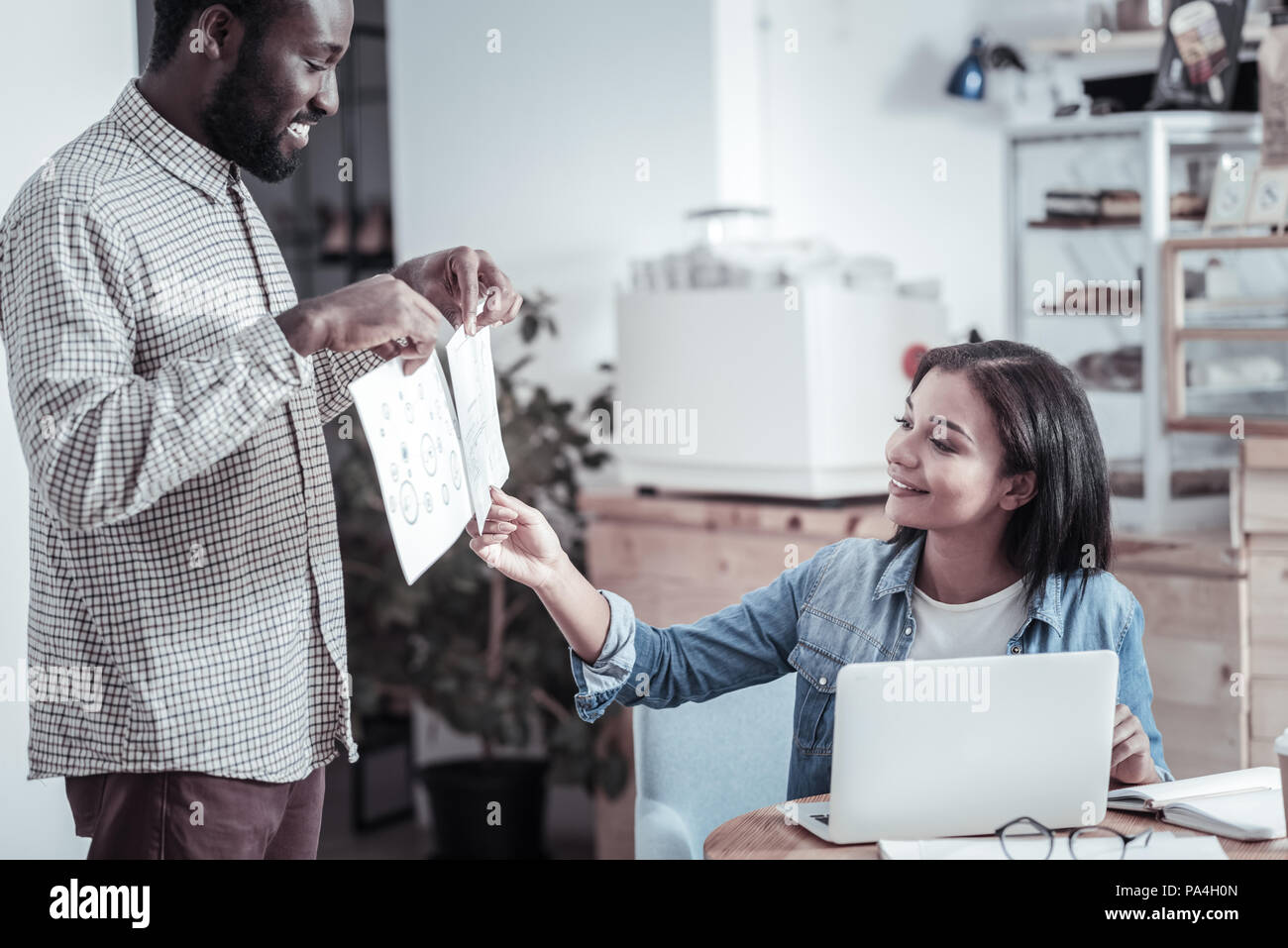 Cheerful positive woman looking at the drawings Stock Photo - Alamy