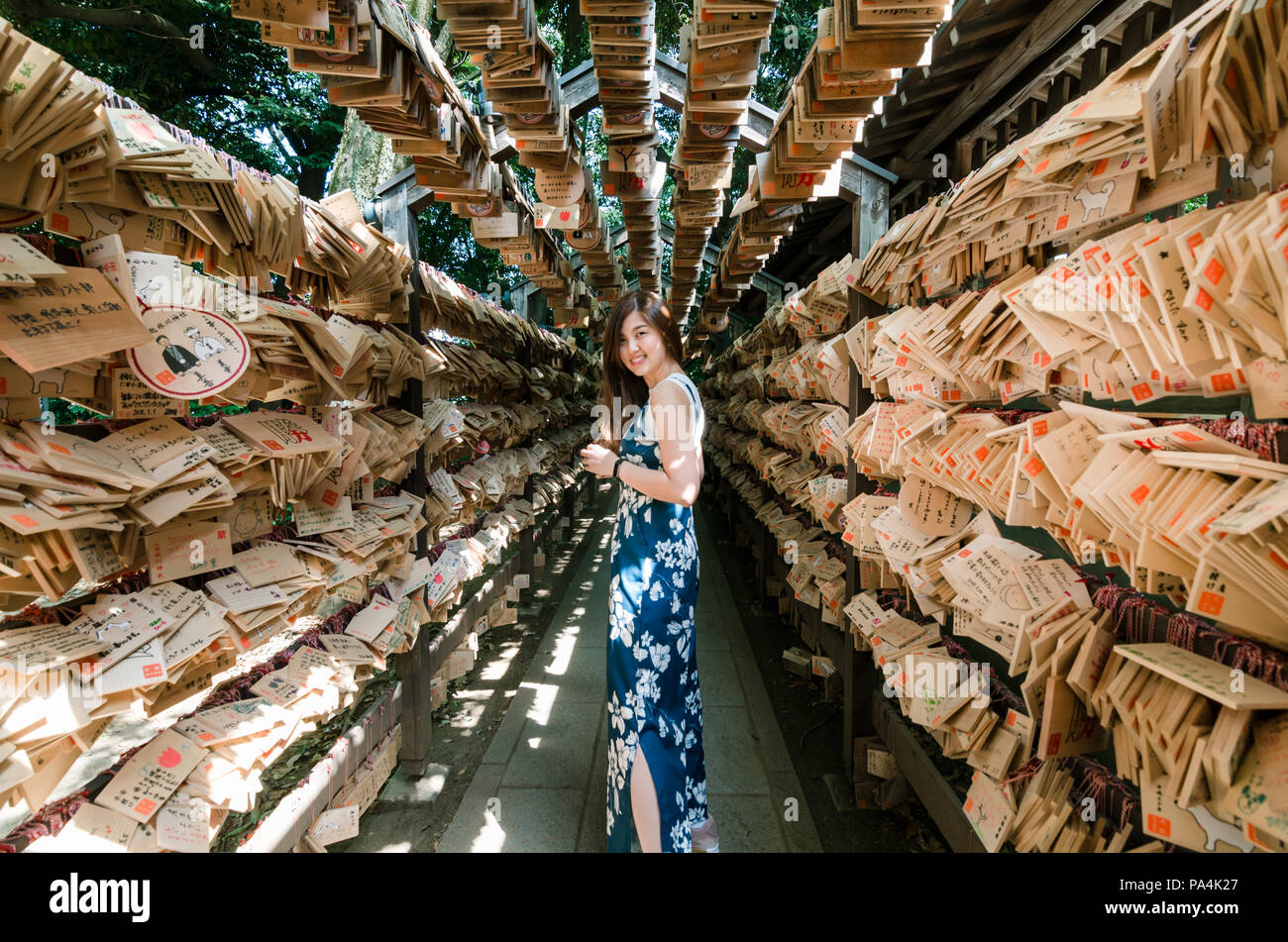 Portrait of beautiful Asian Girl Posing in the Tunnel of Ema- wooden prayer plates at Kawagoe Hikawa Shrine. The shrine is well known for match making Stock Photo