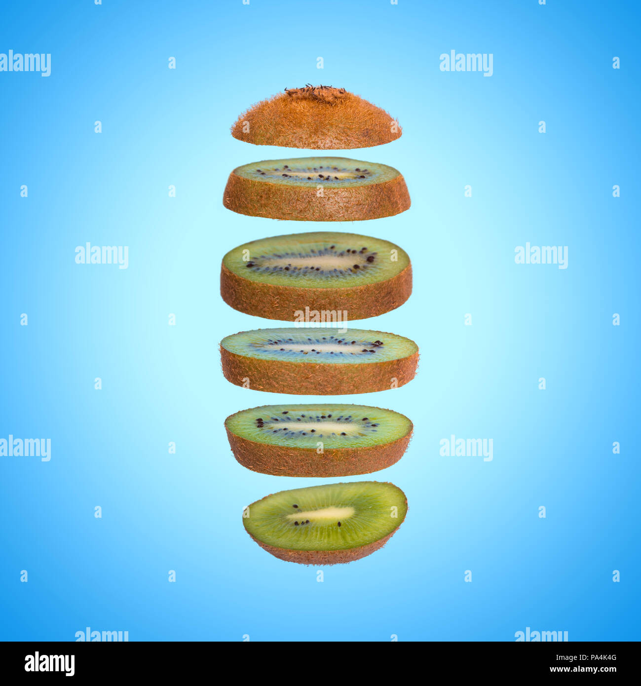 Creative concept with flying kiwi. Sliced kiwi on blue background. Levity fruit floating in the air Stock Photo