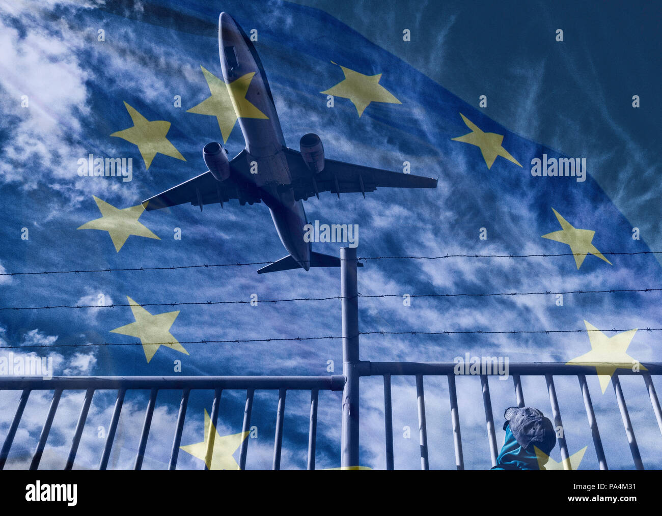 Woman watching aircraft/airplane from behind barbed wire perimeter, border fence. Concept image: Russia Ukraine conflict, no fly zone, refugee crisis. Stock Photo