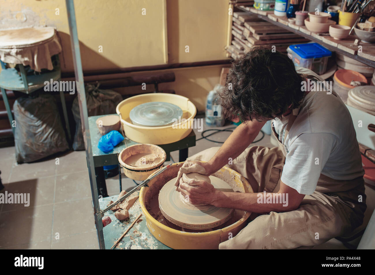 Creating a jar or vase of white clay closeup. Master crock. Man hands