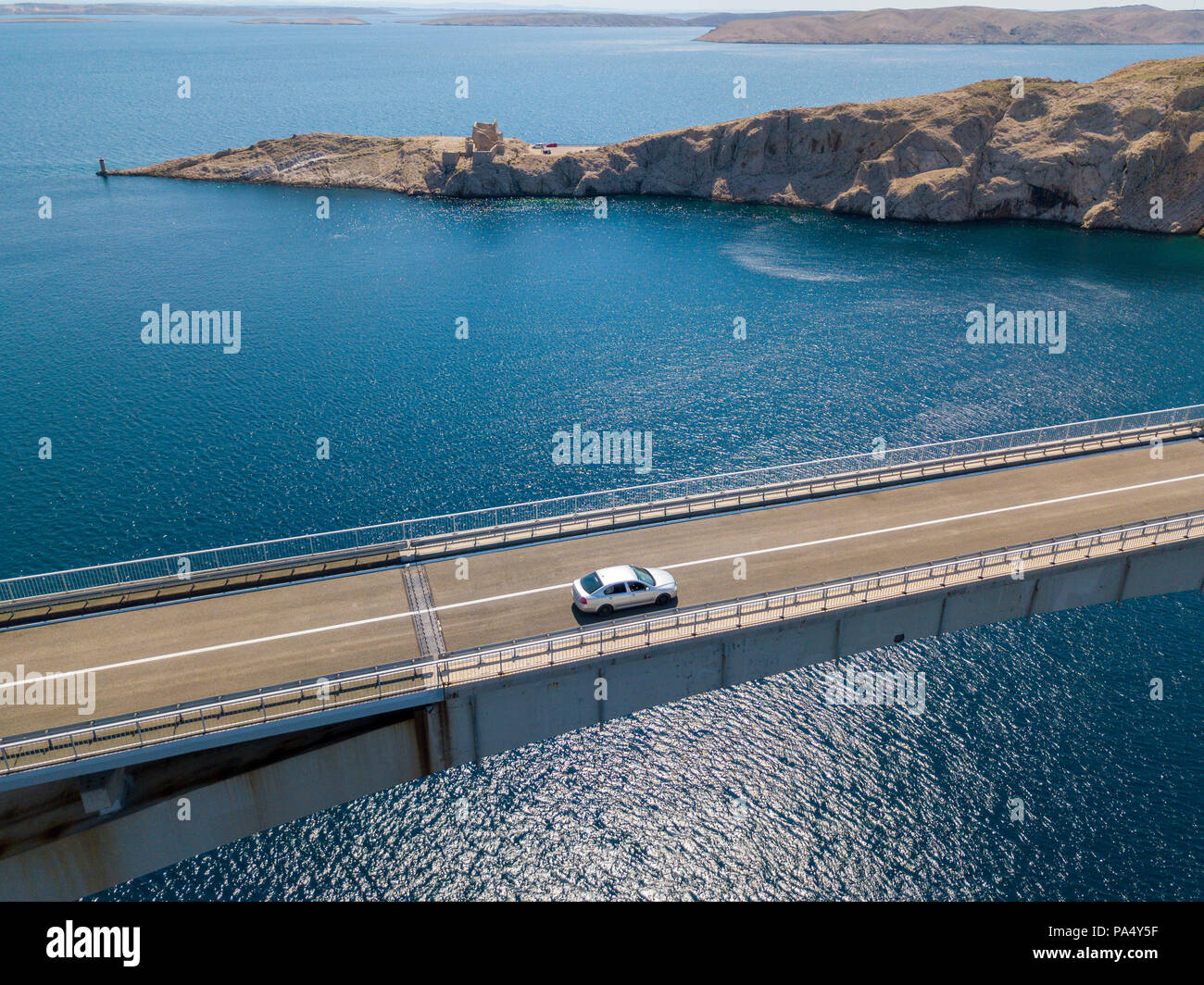 Aerial view of the bridge of the island of Pag, Croatia. Ruins of ancient Fortress Fortica on Pag Island, Croatia. Speedboat passing under the bridge Stock Photo