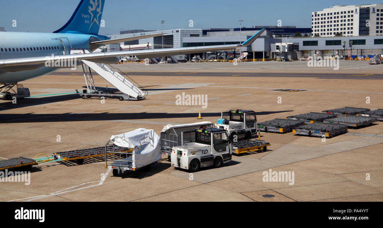 equipment to handle passenger baggage on the apron at London Gatwick Airport Stock Photo