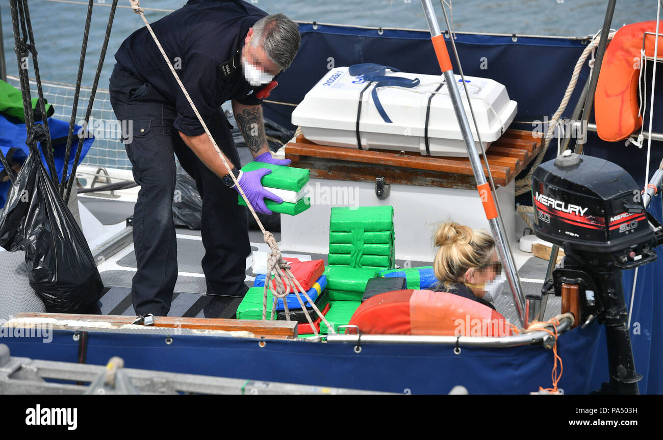 NCA OFFICERS FACES PIXELATED BY PA PICTURE DESK AS REQUESTED BY THE NCA Drugs are unloaded from a boat by officers at Newlyn harbour after the National Crime Agency seized a sailing yacht in the English Channel and bought it back to the harbour, which has been closed temporarily for 'public safety' reasons after the seizure, and arrested two men on suspicion of drug trafficking. Stock Photo