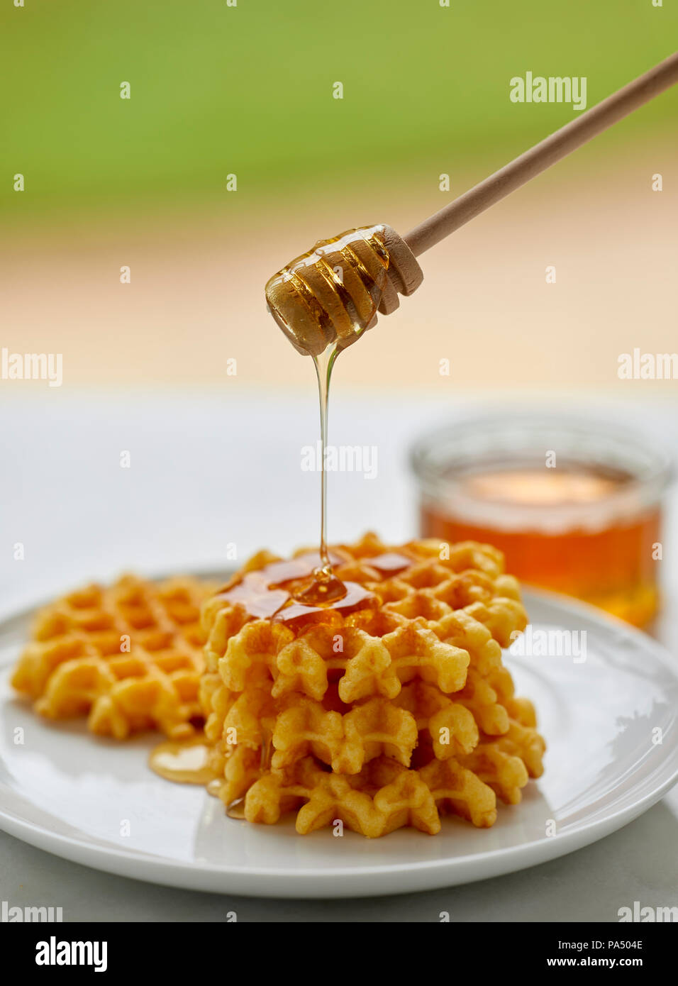 Honey in a jar with wooden dipper Stock Photo