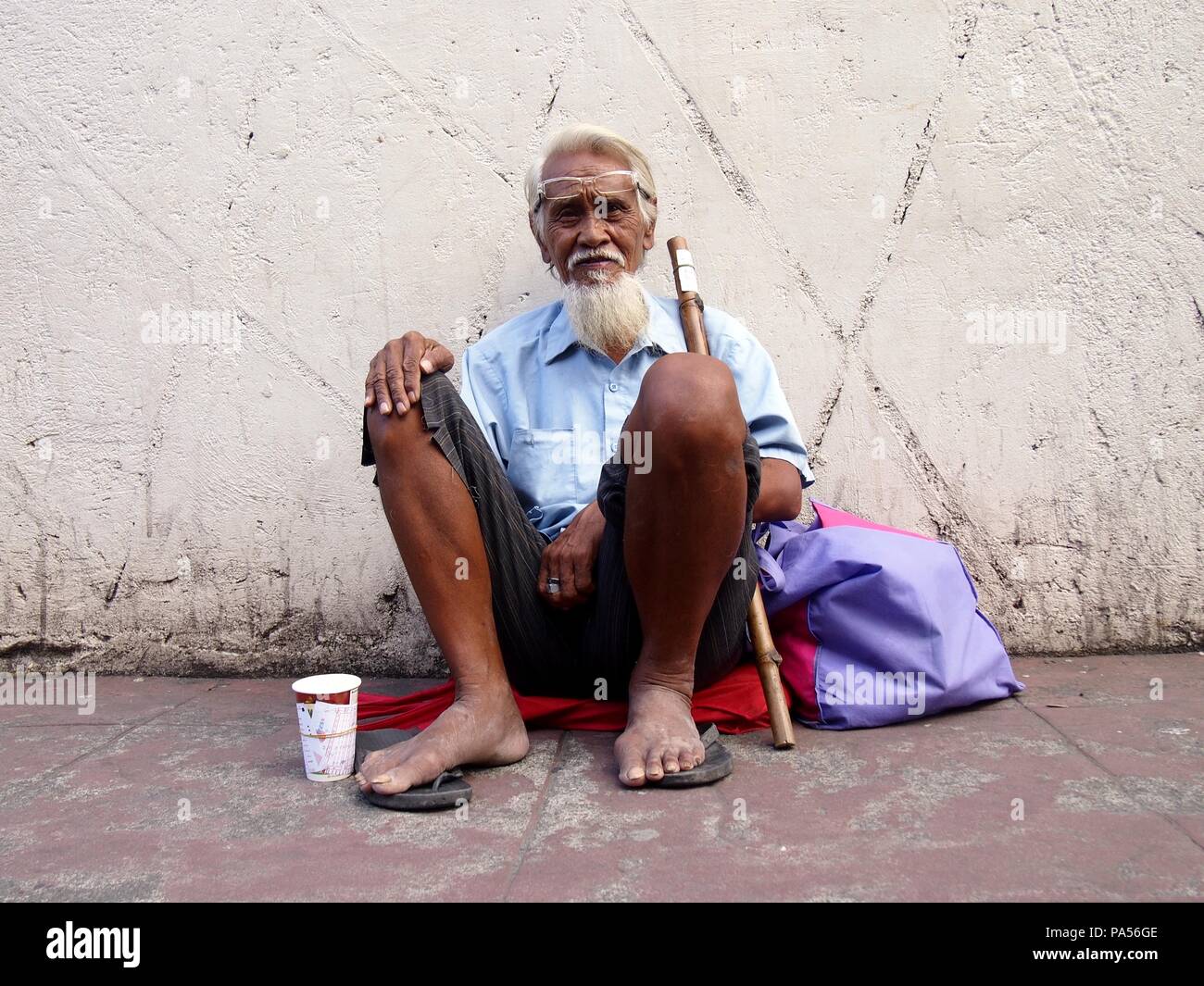 ANTIPOLO CITY, PHILIPPINES NOVEMBER 6, 2015 An elderly beggar sits