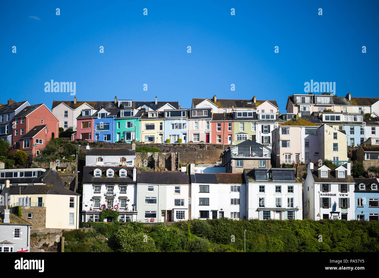 Colourful seaside homes / houses at Brixham, Devon, UK. With bright blue sky Stock Photo Alamy