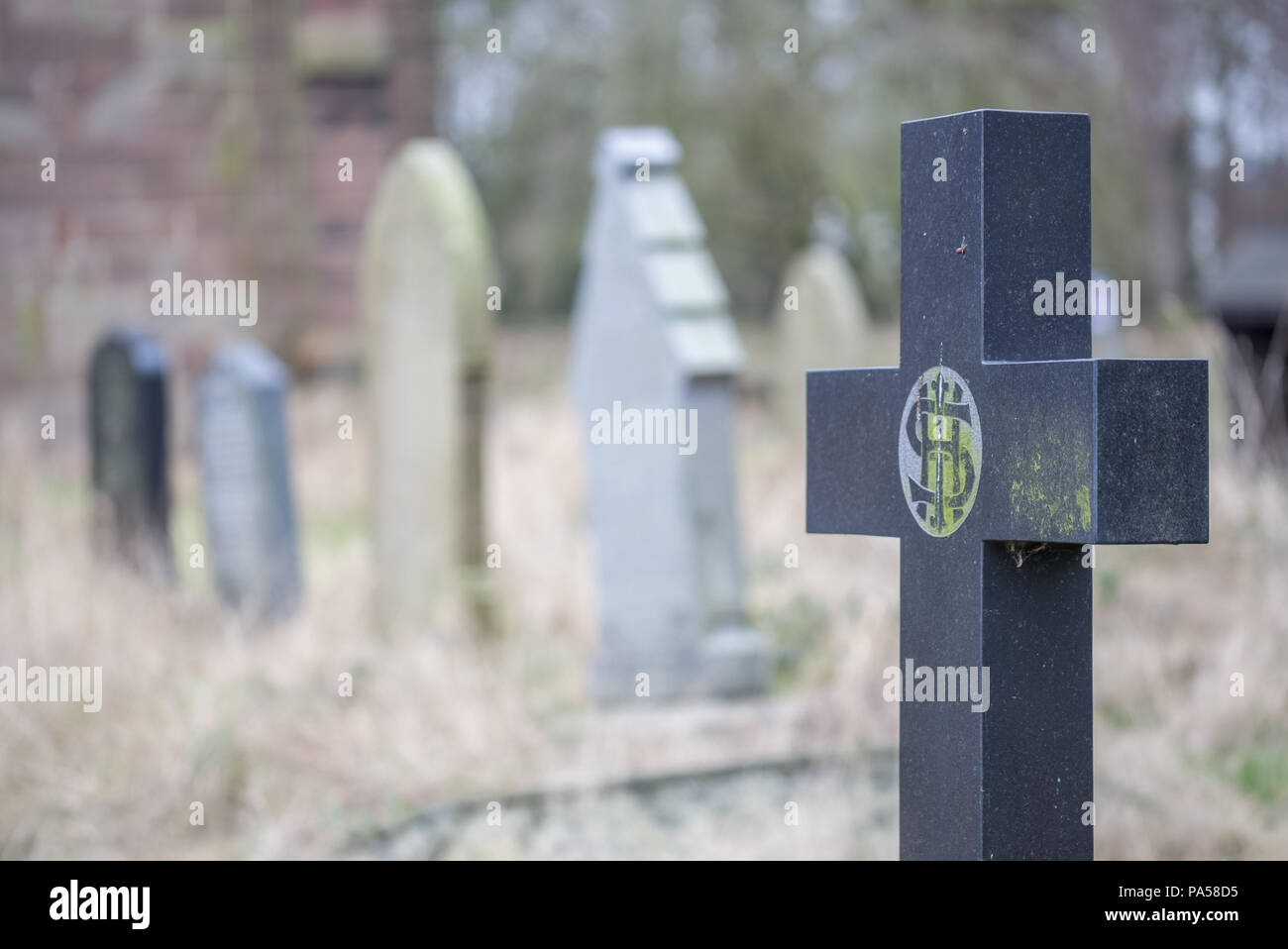 Crucifix headstone in a church yard Stock Photo