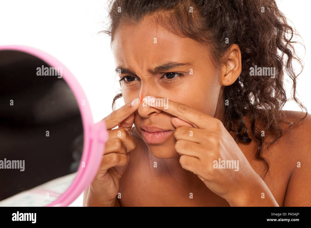 young beautiful black woman squeezing pimples on her nose Stock Photo