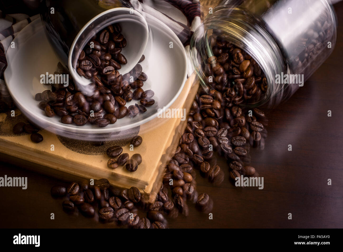 Busy coffee shop with spilt coffee beans on table - dual exposure showing movement Stock Photo