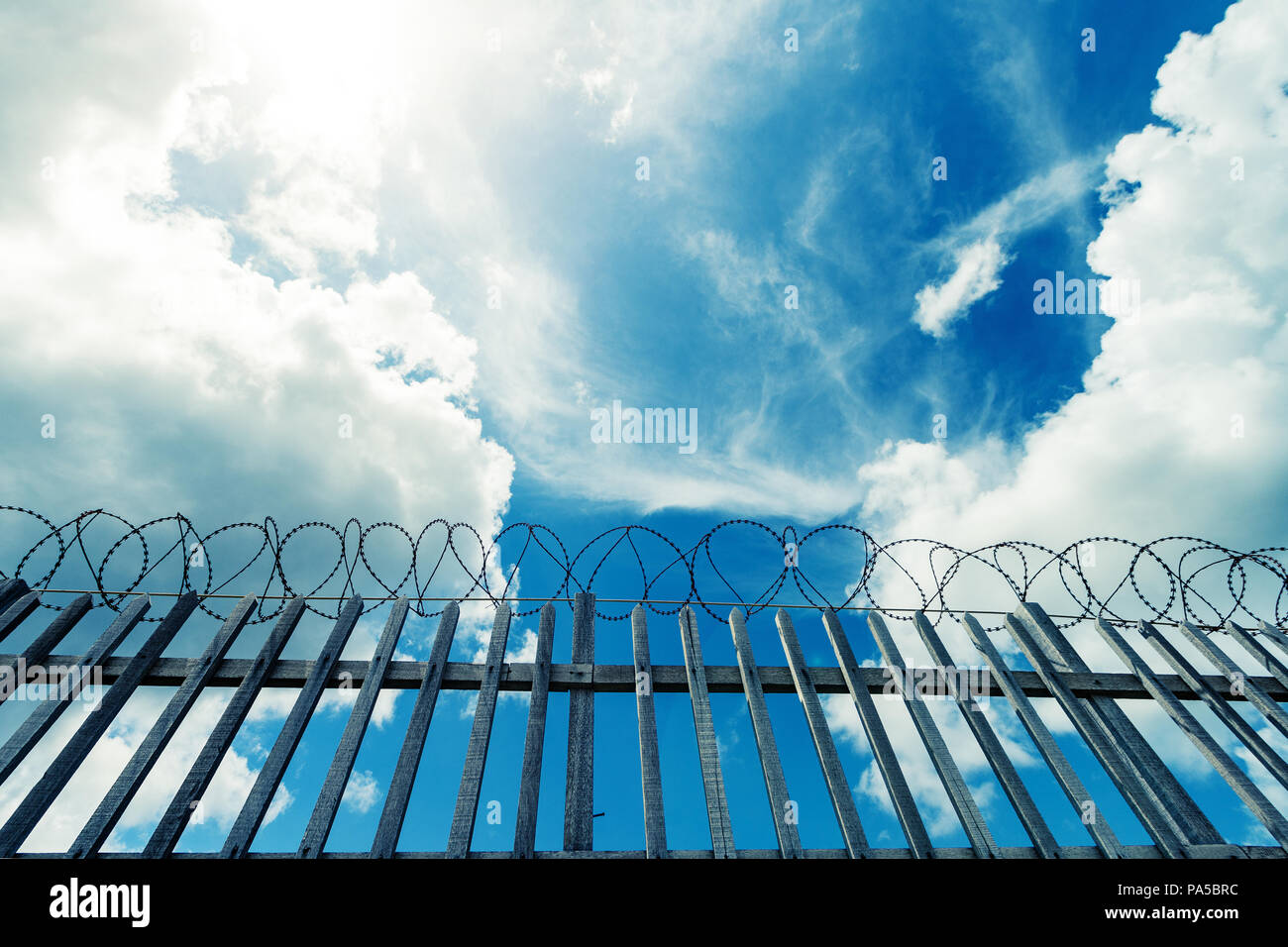 Barbed wire fence surrounding a prison , military or other high security complex. Stock Photo