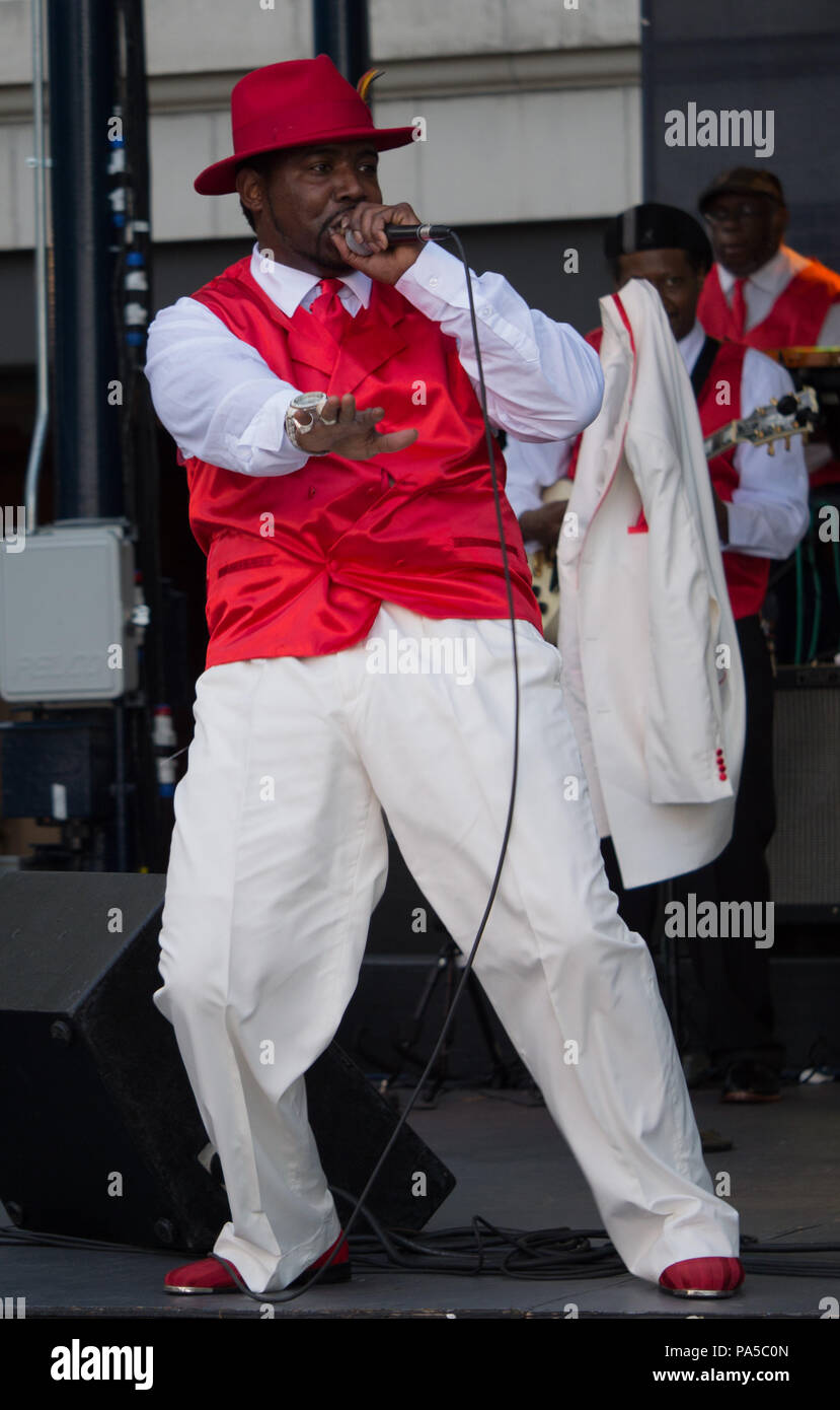 African American R&B singer dressed in red hat and vest white pants and shirt singing and dancing on stage of free summer concert at Navy Pier. Stock Photo
