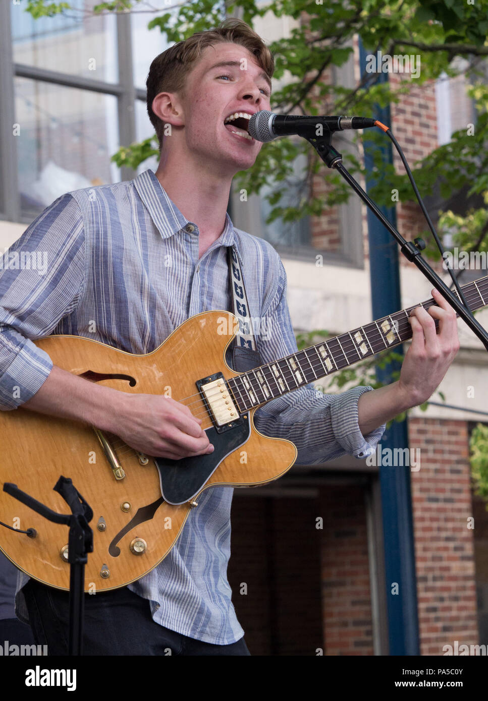 Young rhythm and blues singer playing guitar and entertaining crowd at free summer concert at Navy Pier, Chicago. Stock Photo