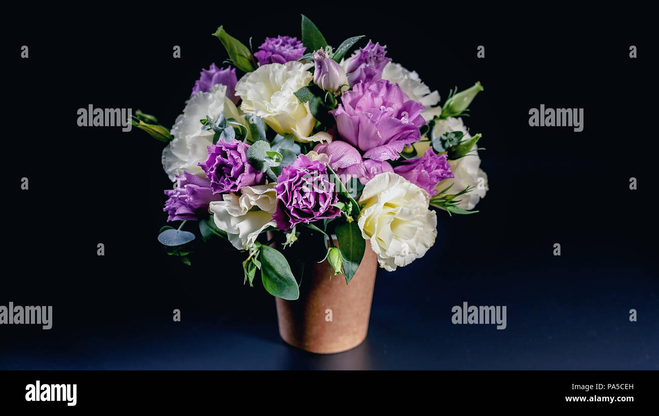 Bouquet of flowers in a coffee cup on a dark blue background. Flower compliment Stock Photo