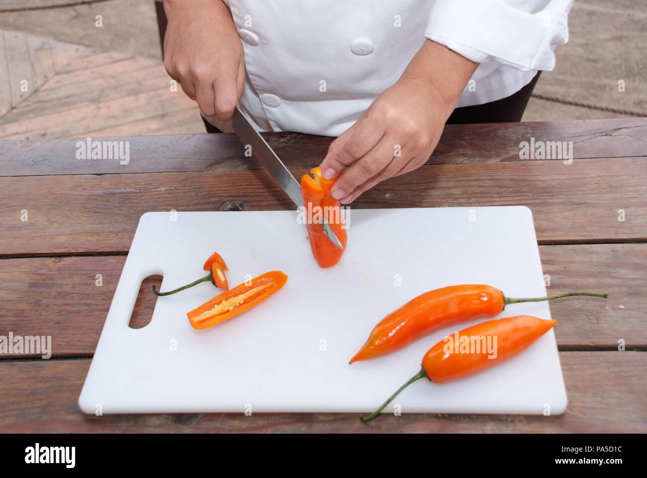 Chef wearing gloves with a sharp knife and clean cuts aji on the white