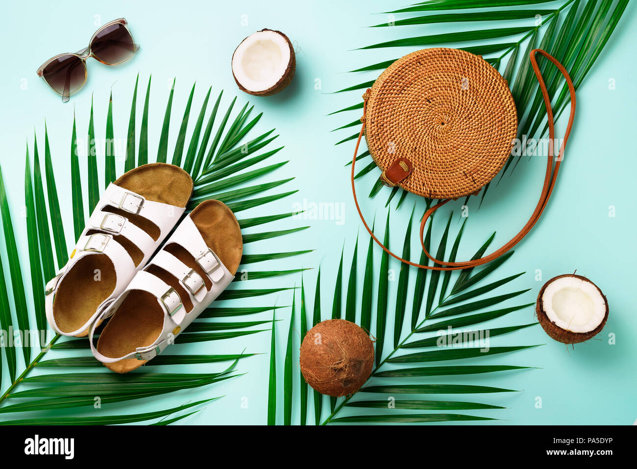 Round rattan bag, coconut, birkenstocks, palm branches, sunglasses on blue  background. Banner. Top view with copy space. Trendy bamboo bag and shoes  Stock Photo - Alamy