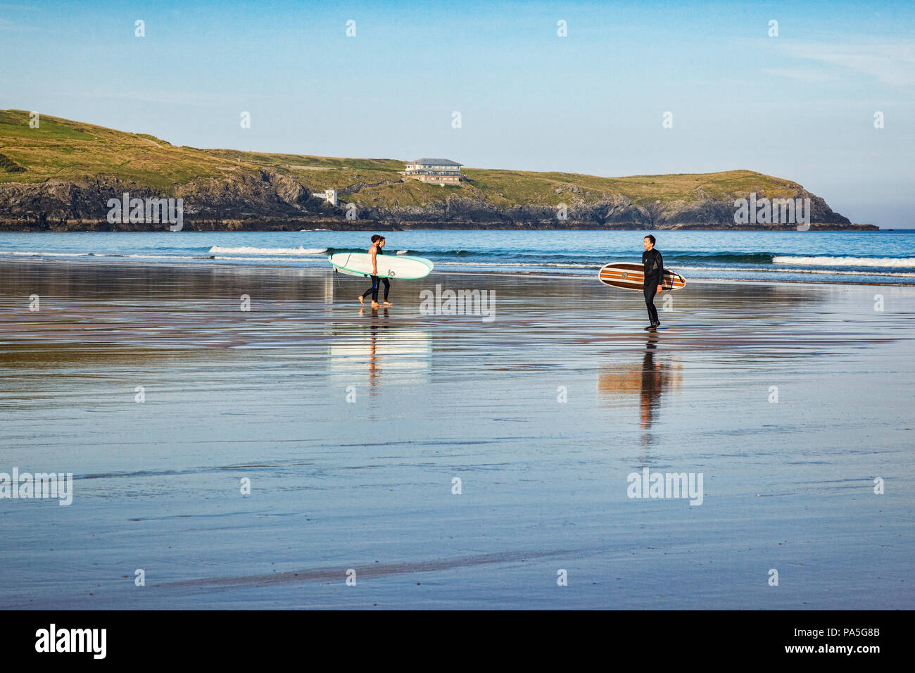 24 June 2018: Newquay, Cornwall, UK - Surfers carrying their boards on Fistral Beach. Stock Photo