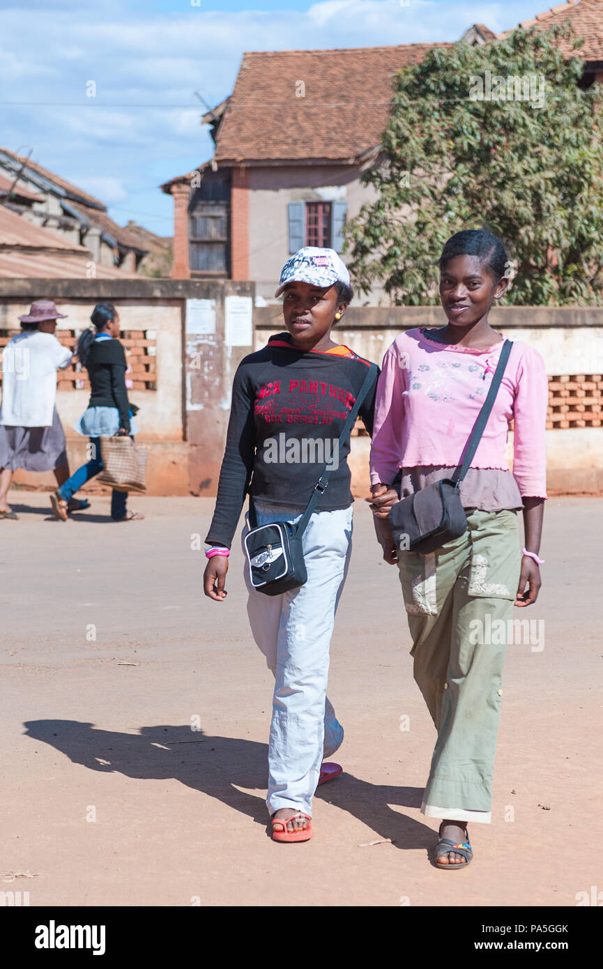 ANTANANARIVO, MADAGASCAR - JULY 1, 2011: Unidentified Madagascar girls walk together in the street. People in Madagascar suffer of poverty due to slow Stock Photo