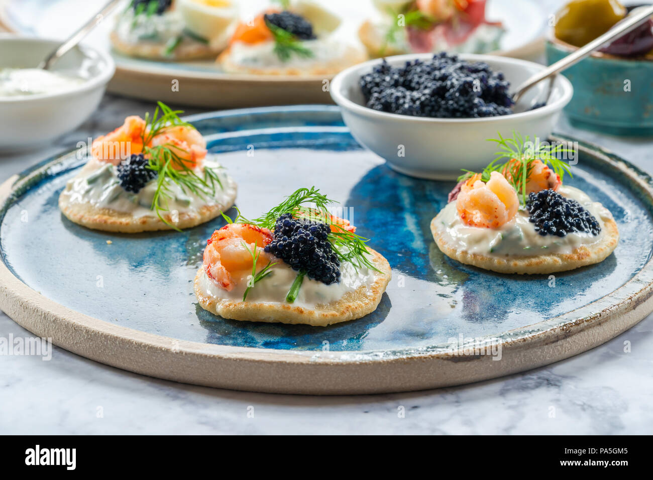 Selection of cocktail blinis with salmon, crayfish, caviar and sour cream - gourmet party food Stock Photo