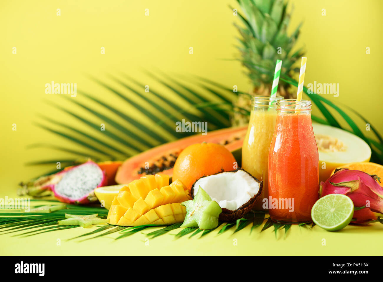 Juicy papaya and pineapple, mango, orange fruit smoothie in two jars on
