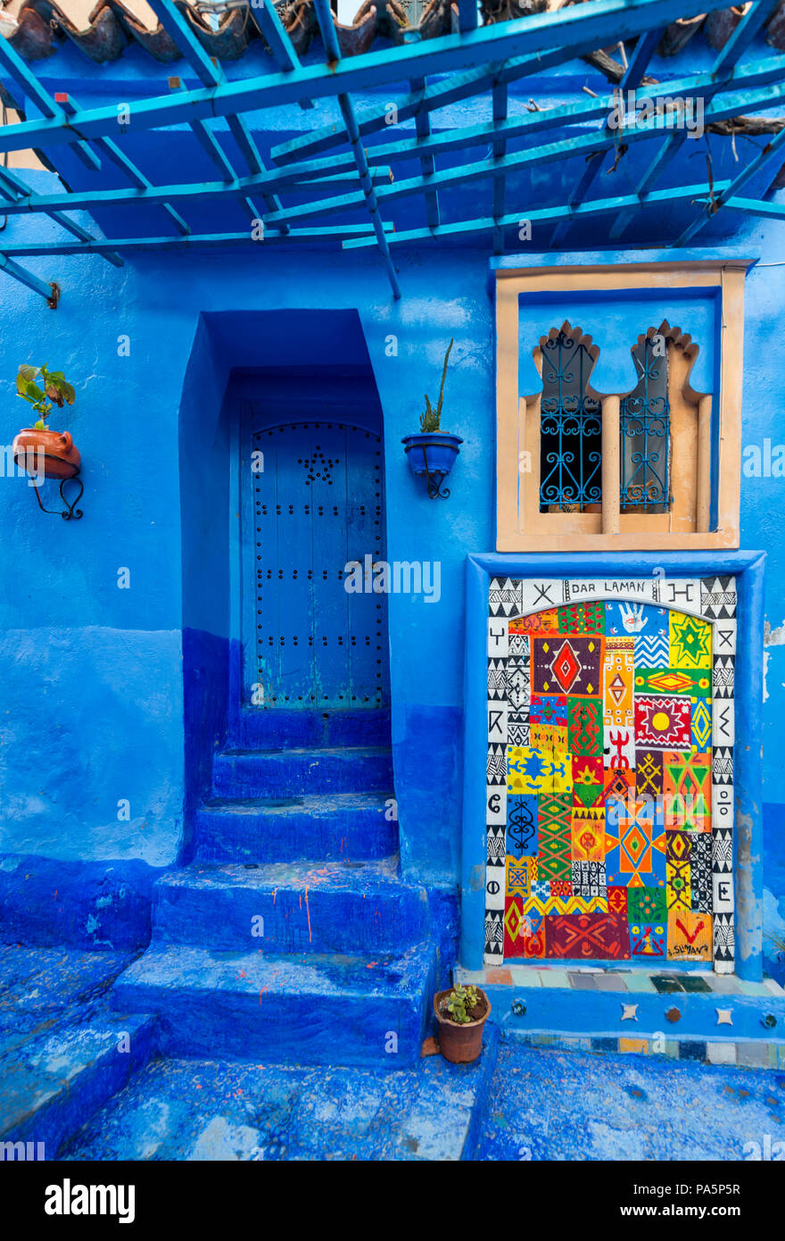 Blue front door, colorful painting on house facade, blue painted house