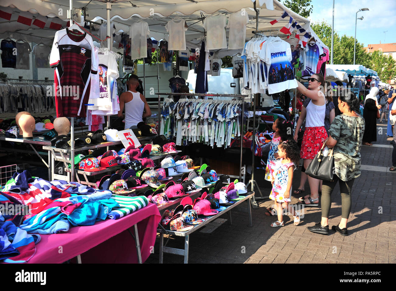 People Looking Around A Bustling Clothes Market In Beziers France - people looking around a bustling clothes market in beziers france