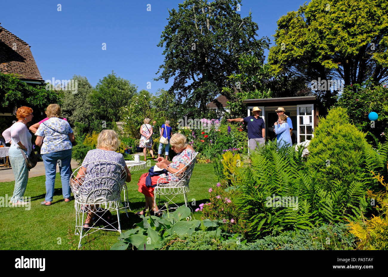 Mainly older people visiting a garden in East Preston under its village open garden scheme Stock Photo