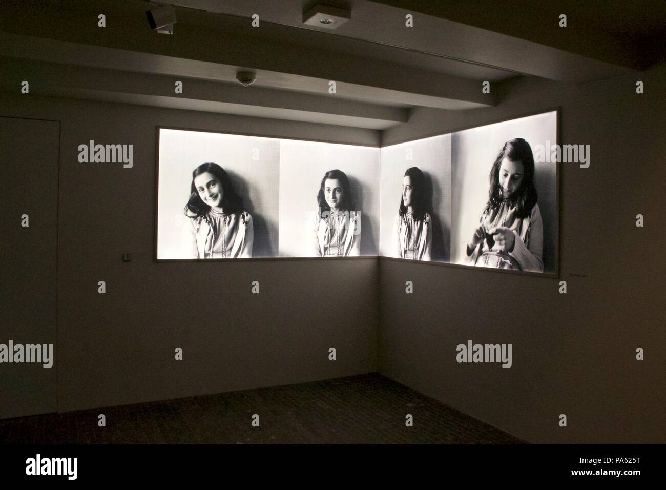 Inside interior of the Anne Frank House Museum in Amsterdam: Four panels showing different photos of Anne Frank in black and white Stock Photo