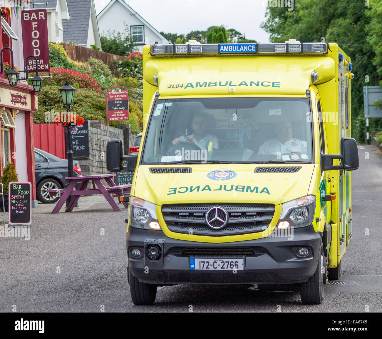 ambulance driving through a village in west cork, Ireland Stock Photo