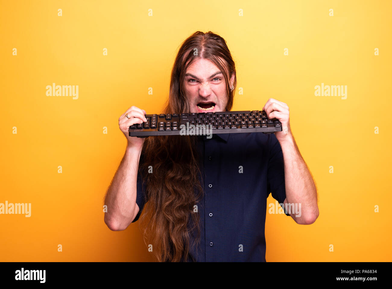 Crazy man eating a keyboard Stock Photo