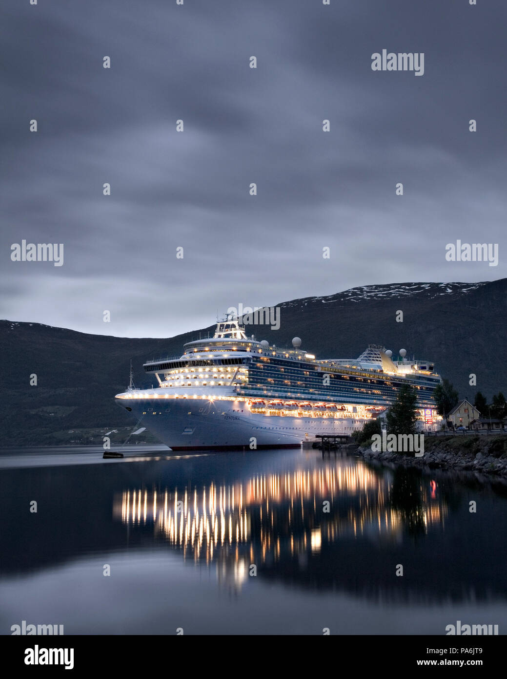 Cruise liner Ventura docked at Olden, Norway at dusk under cloudy skies Stock Photo